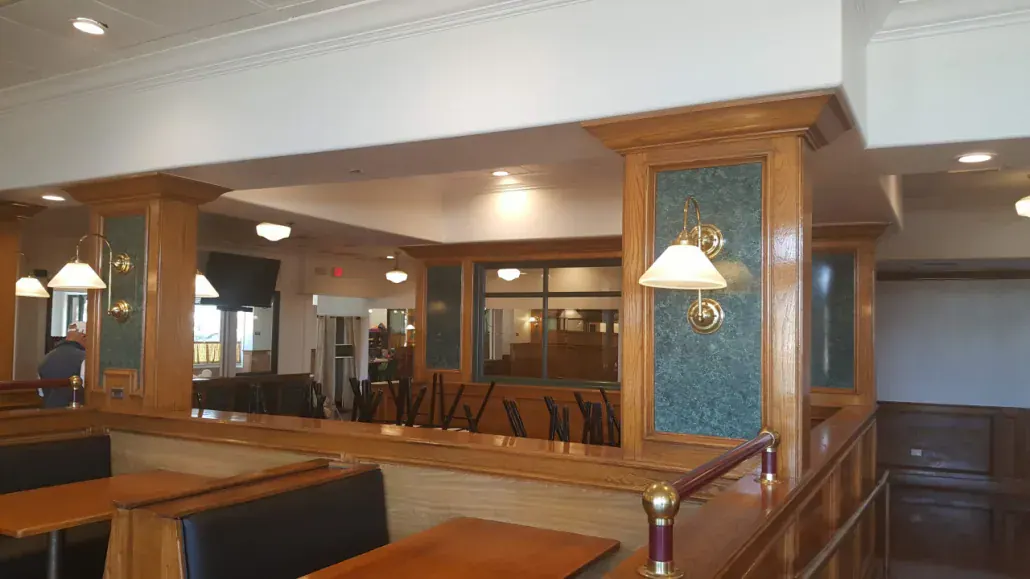 Commercial interior with custom wood millwork, glass display panels and pendant lighting