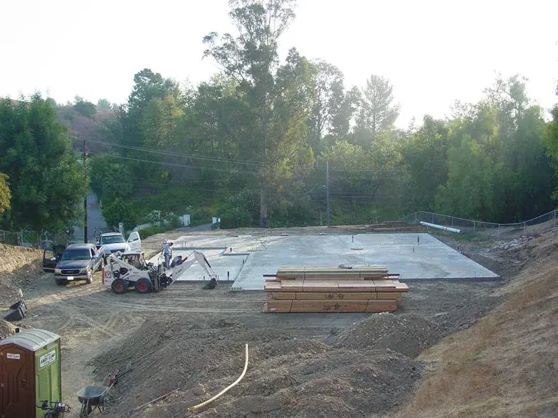 Foundation forms and rebar set on a cleared hillside lot before a concrete pour