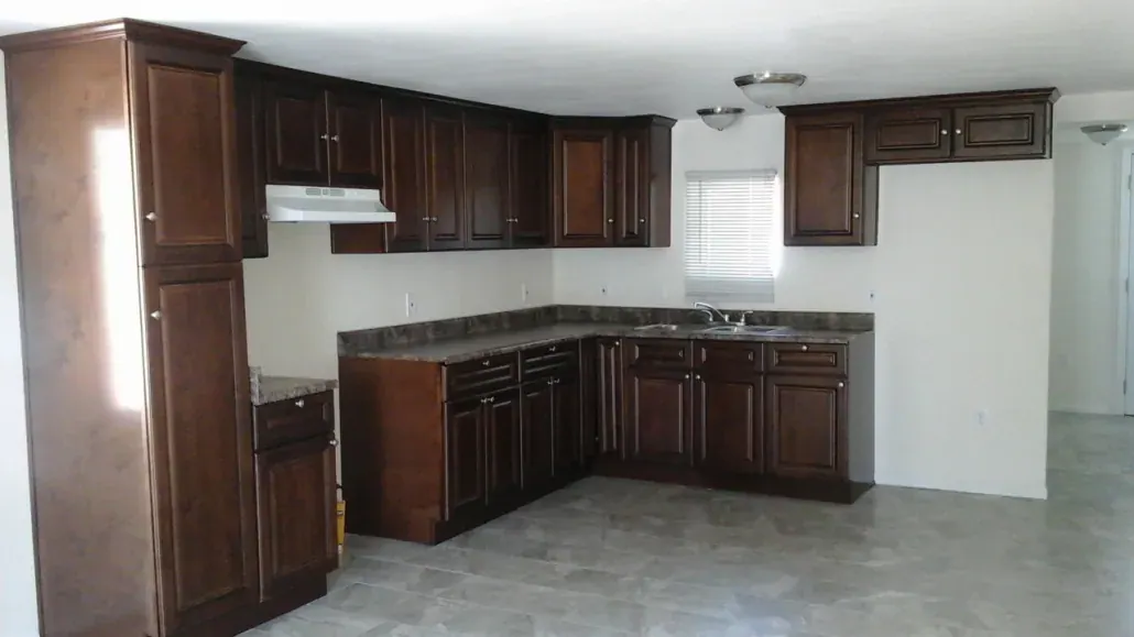Newly installed dark wood kitchen cabinets with granite countertops before final trim and paint